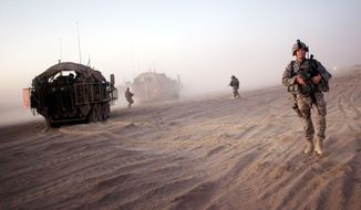 U.S. soldiers from the 5th Stryker Brigade take positions near their armored vehicles during a patrol on the outskirts of Spin Boldak, Afghanistan, in August 2009. Months later, they got the anti-IED gear they requested.  (Associated Press)