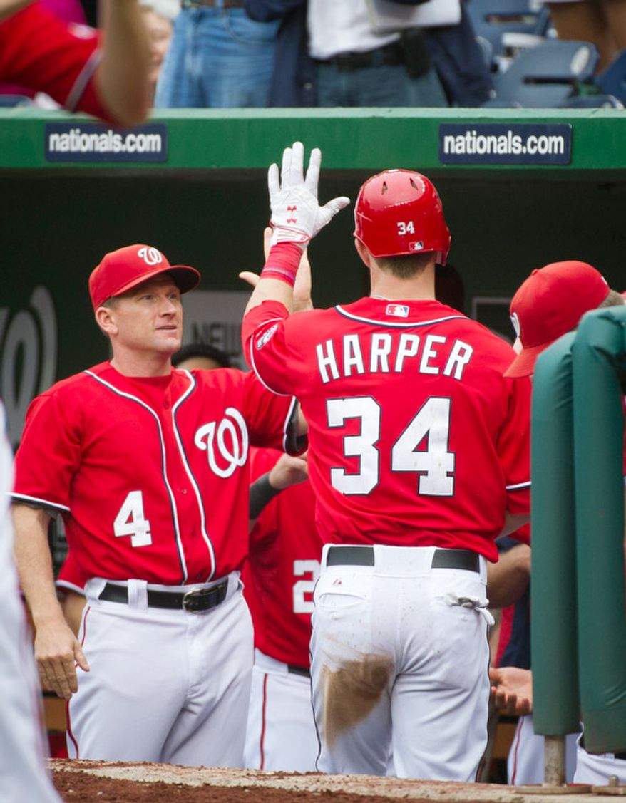 Washington Nationals Bryce Harper is greeted at the dugout by Rick Eckstein (4) after his solo home run in the bottom of the fifth inning. The Nationals defeated the Mets 5-2. (Rod Lamkey Jr./The Washington Times)