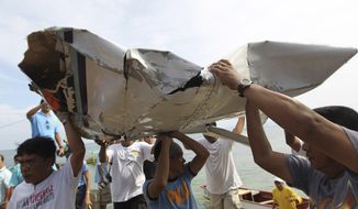 Men carry parts of a crashed plane that was carrying Philippine Interior Secretary Jesse Robredo in Masbate, Philippines, on Sunday, Aug. 19, 2012. About 300 rescuers were searching for Mr. Robredo and his two pilots after their small plane crashed into the sea while attempting an emergency landing Saturday. (AP Photo/Malacanang Photo Bureau, Jay Morales)