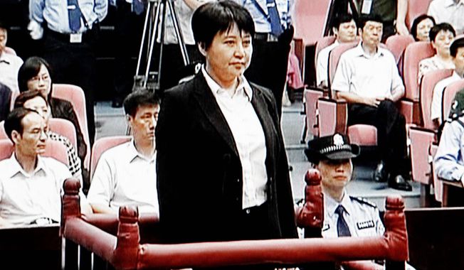 Gu Kailai (center), the wife of disgraced politician Bo Xilai, stands during her trial in the Hefei Intermediate People’s Court in Hefei in eastern China’s Anhui province earlier this month. Gu was given a suspended death sentence on Monday. (Associated Press)