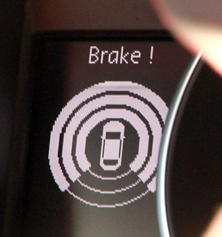 An onboard device instructs a motorist to brake during a driving simulation Tuesday in Ann Arbor, Mich. The driving simulation was part of a news event marking the start of a yearlong test of cars that can communicate with each other. Carmakers Ford, General Motors, Honda, Hyundai/Kia, Mercedes-Benz, Nissan, Toyota and Volkswagen/Audi all are supplying vehicles and taking part in the test. Officials say eventually this could lead to the devices going in every car. (Associated Press)