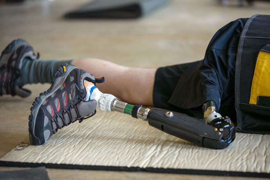 SFC Josh Olson, a U.S. Army Paralympic marksman, prosthetic leg supports him in preparation to shoot his rifle at Wagner Range, in Ft. Benning, Ga., Thursday, May 31, 2012. Olson sustained heavy damage to his leg during an ambush attack in Iraq in 2003, in which his right leg had to be amputated. He's currently a apart of the wounded warrior program and the first active duty soldier to qualify for a Paralympics in the field of mixed 50 meter rifle and mixed 10 meter air rifle. (Andrew S. Geraci/The Washington Times)
