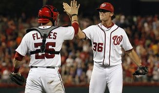 Washington Nationals catcher Jesus Flores celebrates with closer Tyler Clippard after the Washington Nationals closed out a 4-1 win over the Atlanta Braves on Tuesday, Aug. 21, 2012, in Washington. (AP Photo/Alex Brandon)
