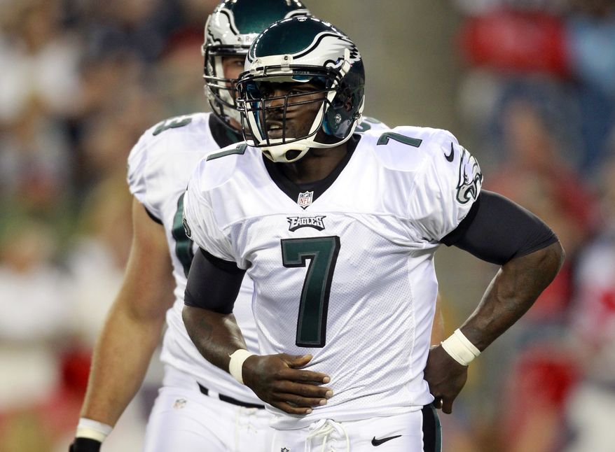 **RETRANSMITTED WITH ALTERNATE CROP FBO110**Philadelphia Eagles quarterback Michael Vick (7) holds his mid-section after getting hit hard by New England Patriots linebacker Jermaine Cunningham (96) during the first quarter of an NFL preseason football game in Foxborough, Mass., Monday, Aug. 20, 2012. Vick left the game after the play. (AP Photo/Steven Senne)