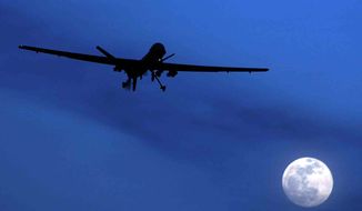 ** FILE ** An unmanned U.S. Predator drone flies over Kandahar Air Field in southern Afghanistan on a moonlit night in January 2010. (AP Photo/Kirsty Wigglesworth)

