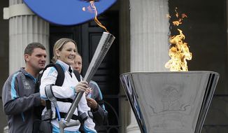 Claire Lomas lights the Paralympic flame cauldron in Trafalgar Square in London, Friday, Aug. 24, 2012. Claire had a horse riding accident in 2007 leaving her paralysed from the chest down.  The London Paralympics begin on Wednesday Aug. 29.(AP Photo/Kirsty Wigglesworth)