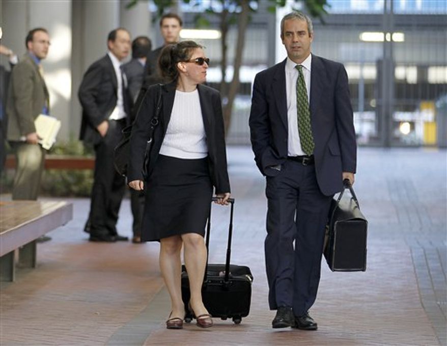 Kevin Johnson, right, and Victoria Maroulis, left, attorneys for Samsung, leave the US Courthouse and Federal building after a jury reached a decision in the Apple Samsung trial on Friday, Aug 24, 2012 in San Jose, Calif. After a year of scorched-earth litigation, a jury decided Friday that Samsung ripped off the innovative technology used by Apple to create its revolutionary iPhone and iPad. The jury ordered Samsung to pay Apple $1.05 billion. An appeal is expected. (AP Photo/Tony Avelar)