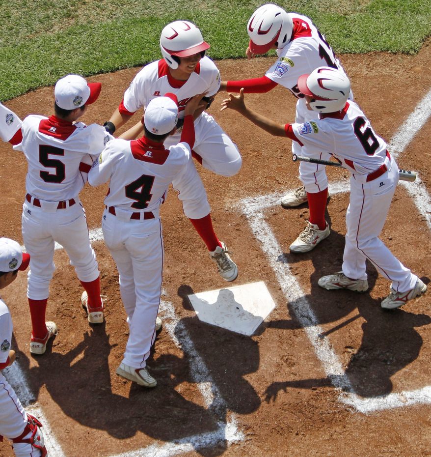 Tokyo's Satoru Aoyama leaps on home plate and celebrates with teammates after hitting a solo home run off Aguadulce, Panama, pitcher James Gonzalez in the first inning of the international championship baseball game at the Little League World Series, Saturday, Aug. 25, 2012, in South Williamsport, Pa. Tokyo won 10-2. (AP Photo/Gene J. Puskar)