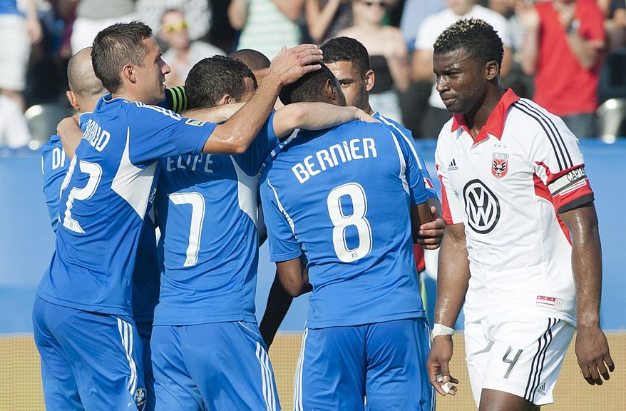 D.C. United's Brandon McDonald, right, walks by as players from the Montreal Impact celebrate after Patrice Bernier scored during second half MLS soccer action in Montreal, Saturday, Aug. 25, 2012. (AP Photo/The Canadian Press, Graham Hughes)