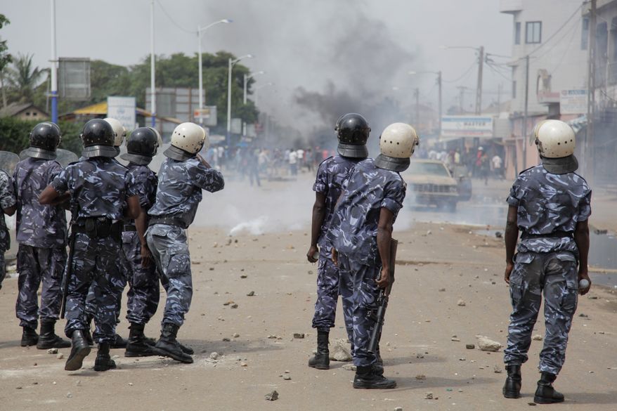 ** FILE ** Togolese security forces fire tear gas as they attempt to disperse thousands of angry opposition protesters and anti-government militants on the first day of a planned three-day rally in central Lome, Togo, on Tuesday, Aug. 21, 2012. The demonstrators set fire to tires, threw rocks and erected street barricades as they rallied to protest new electoral rules, perceived to favor the ruling party. (AP Photo/Erick Kaglan)