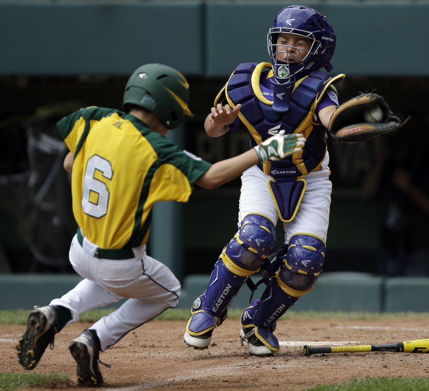 Petaluma, Calif.'s Porter Slate (left) scores past Aguadulce, Panama's Edgar Victoria on a hit by Logan Douglas in the fifth inning of the consolation baseball game at the Little League World Series on Sunday, Aug. 26, 2012, in South Williamsport, Pa. California won 12-4. (AP Photo/Matt Slocum)