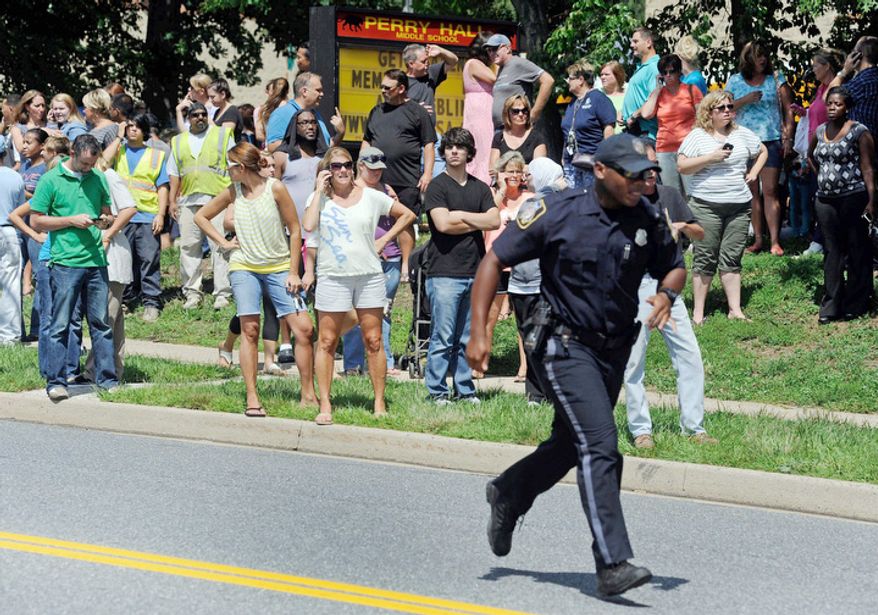 Parents wait to reunite with their children after a student was shot and critically wounded on the first day of classes at Perry Hall High School, Monday, Aug. 27, 2012, in Perry Hall, Md. A suspect was taken into custody shortly after the shooting, according to police. No one else was reported injured. (AP Photo/Steve Ruark)