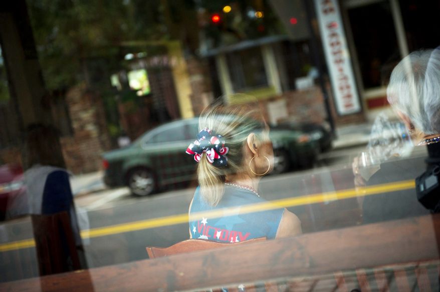 A woman is seen at a table as delegates from Maryland take shelter from the spotty rain at Gaspar's Grotto as tropical storm Isaac delays the kickoff of Republican National Convention in Ybor City, Fla., Monday, August 27, 2012. (Rod Lamkey Jr./The Washington Times)