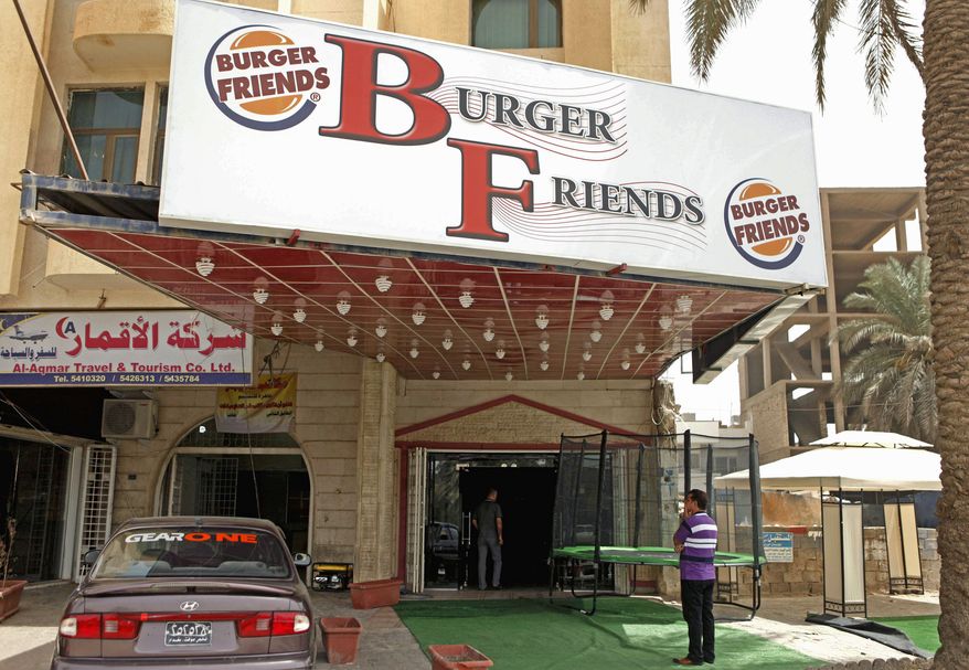 A customer stands outside Burger Friends restaurant. An Iraqi doctor said he fears the popularity of American-style food will make children fatter. Iraqi entrepreneurs and foreign investors are driving the food craze. (Associated Press)