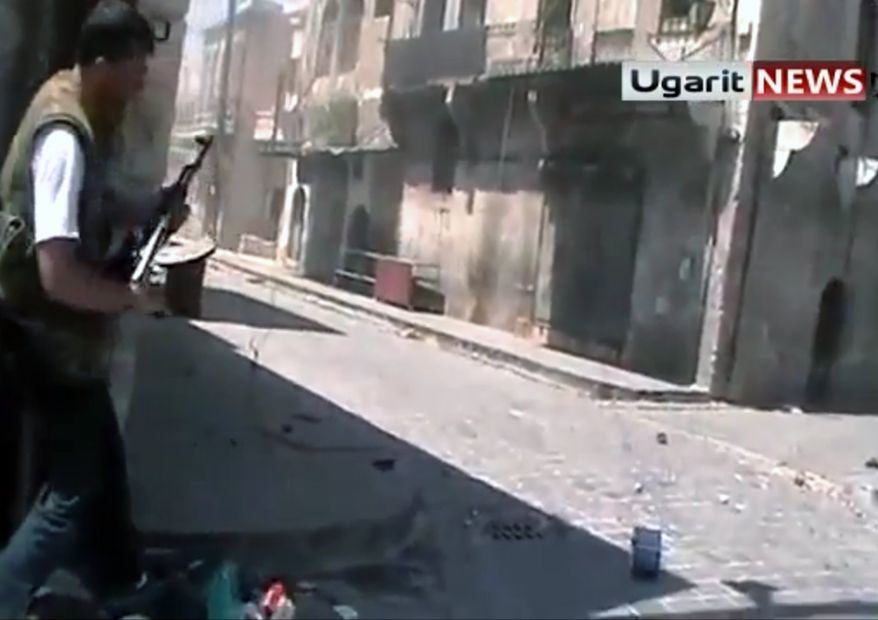 ** FILE ** In this frame grab made from amateur video provided by Ugarit News, taken on Sunday, Aug. 26, 2012, purports to show a member of the rebel group, the Unification Brigade, as he prepares to fire his weapon at a group of Assad soldiers in street fighting in Aleppo, Syria. The Associated Press is unable to independently verify the authenticity, content, location or date of this citizen journalist image. (AP Photo/Ugarit News via AP video)