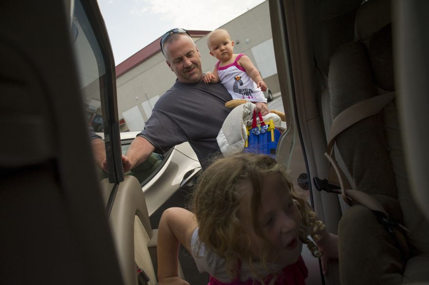 Joe Carr makes a run picking up his daughter Olivia, 8 months and Catalina, 5, at the end of the day in Downingtown, Pa., Friday, August 17, 2012. Mr. Carr and his wife Sofia were at one point unemployed at the same time. The home they own was a foreclosed property which they renovated and currently live in. (Rod Lamkey Jr./The Washington Times)