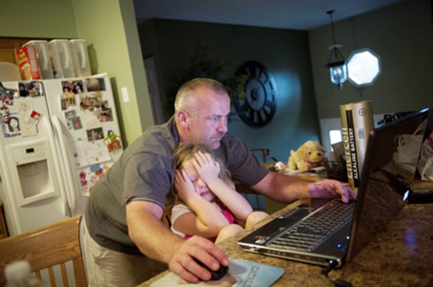 Joe Carr helps his daughter Catalina, 5, with a computer game at their home in Downingtown, Pa., Friday, August 17, 2012. Mr. Carr and his wife Sofia were at one point unemployed at the same time. Sofia has returned to paralegal work and Joe has returned to work at the same construction company that laid him off recently. The home they own was a foreclosed property which they renovated and currently live in. (Rod Lamkey Jr./The Washington Times)