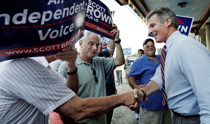 Sen. Scott P. Brown, Massachusetts Republican, greets voters in Dedham, Mass.. He is seeking re-election as more of a centrist than a tea party favorite, a status that aided his candidacy last time. (Associated Press)