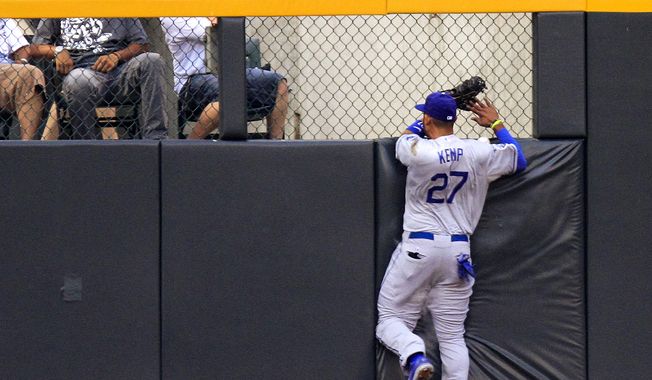 Los Angeles Dodgers center fielder Matt Kemp (27) slams into the wall chasing a Colorado Rockies' Josh Rutledge triple during the first inning of a baseball game, Tuesday, Aug. 28, 2012, in Denver. Kemp was injured on the play. (AP Photo/Barry Gutierrez)