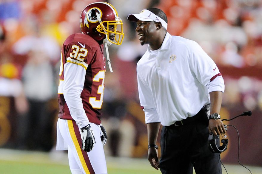 Raheem Morris (R) talks with Washington Redskins defensive back Brandyn Thompson (32) during a break in action. (Preston Keres/Special to The Washington Times)