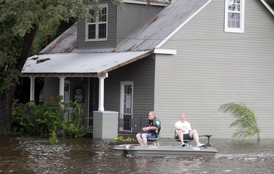 Two men use a small boat to travel Aug. 30, 2012, though flooded streets in Slidell, La. Isaac's maximum sustained winds had decreased to 45 mph and the National Hurricane Center said it was expected to become a tropical depression by Thursday night. (Associated Press)