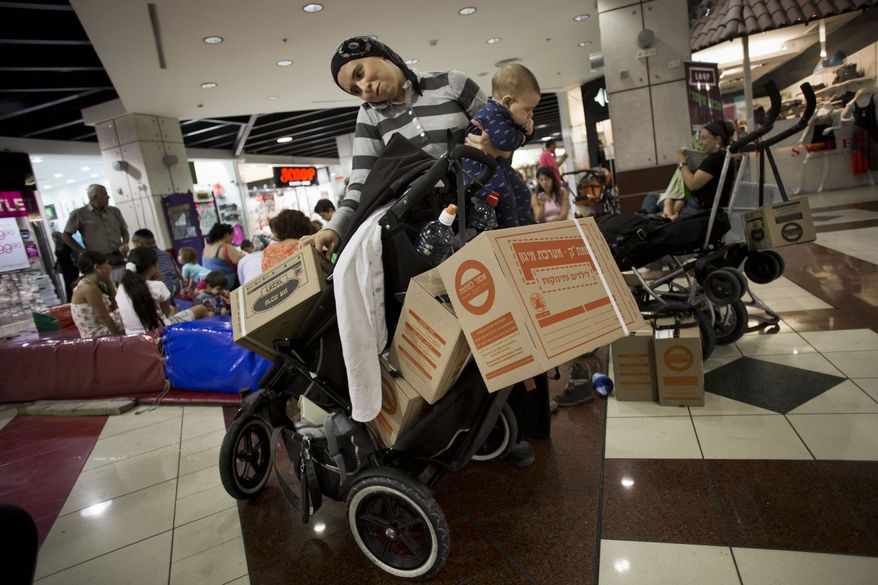 In this Wednesday, Aug. 22, 2012 photo, an Israeli woman talks on the phone after collecting gas masks for her family in a shopping mall in Jerusalem. A new U.N. report adds credibility to Israel's warnings about Tehran's nuclear ambitions, Israeli officials said Friday, commenting on findings that could provide ammunition to Israeli calls for military action against Iran's suspect nuclear program at a time when the U.S. and other allies are pressing the Jewish state to hold its fire. (AP Photo/Bernat Armangue)