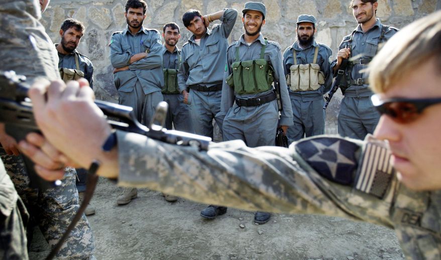 Afghan National policemen look on as Cpl. Joseph Dement, from the 2nd Battalion, 12th Infantry Regiment, 4th Brigade Combat Team, 4th Infantry Division, conducts a training in 2009. (Associated Press)