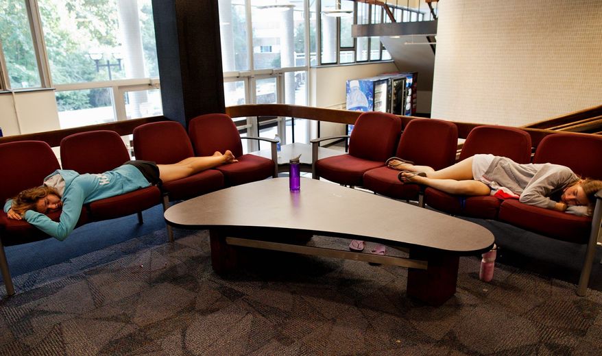 Michigan Science, Technology, Engineering and Mathematics Academy members Noelle Hansford (left) and Andrea Case take a nap in the lobby of Bursley Hall on the campus of the University of Michigan in Ann Arbor, Mich., recently. About three-quarters of all college students have indicated having occasional sleep problems. (Associated Press)
