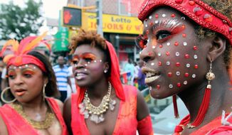 Angelana Jones (right) waits with others to take part in the West Indian Day Parade in the Brooklyn borough of New York on Monday. Women in brightly colored sequined costumes and feather headdresses danced to reggae.
