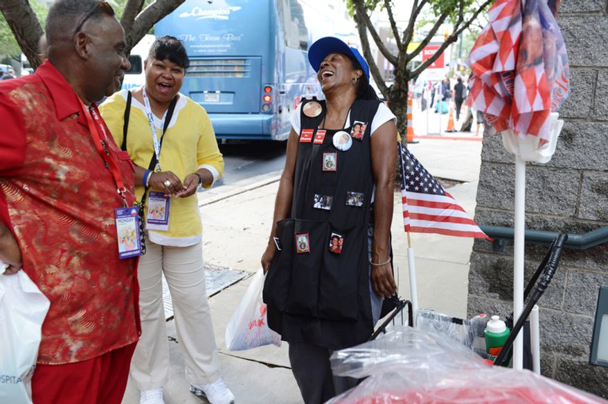 Claudia Blakemore, right, a registered nurse from Houston, Tex., laughs with Howard Foreman, left, from Vinton, La., and Audrey Cumby of LaMarque, Tex., outside the Charlotte Convention Center in Charlotte, N.C. Blakemore drove to the convention to sell Obama memorabilia, including hats, buttons and flags. She also sold things at the last DNC in 2008. (Barbara L. Salisbury/The Washington Times)