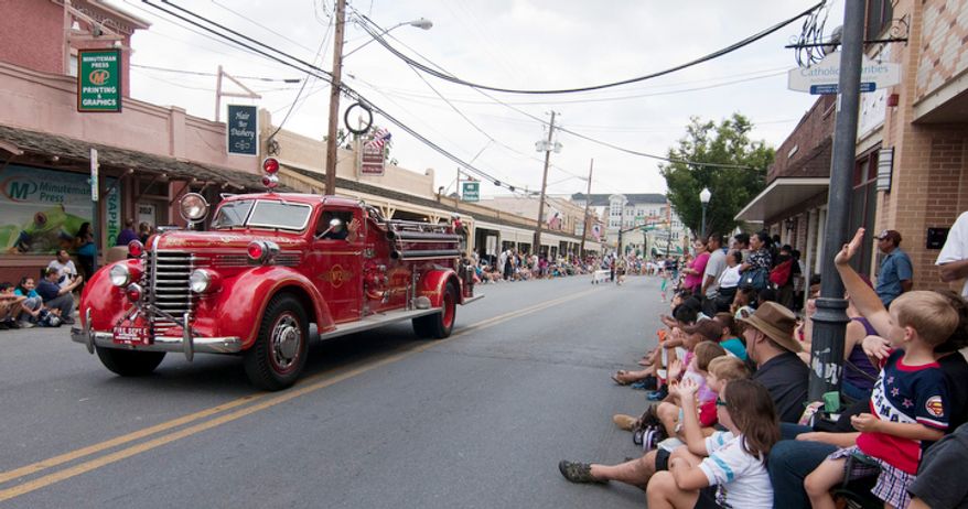 Over a dozen firetrucks ride in the Gaithersburg Labor Day parade. (Craig Bisacre/The Washington Times)