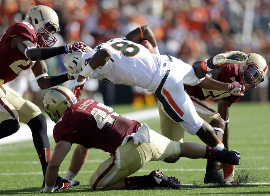 Miami running back Duke Johnson (8) carries the ball against Boston College defensive back Jim Noel (23), linebacker Steele Divitto (49), and defensive back Manuel Asprilla (21) in the first half of an NCAA college football game at Alumni Stadium in Newton, Mass. Saturday, Sept. 1, 2012. Miami won 41-32. (AP Photo/Elise Amendola)