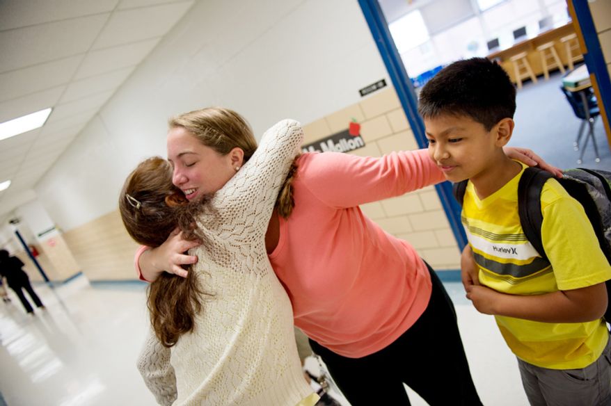 2nd grade teacher Ali Mallon hugs Brandon Romero's mother, on Brandon's first day back to school at North Springfield Elementary School. (Andrew Harnik/The Washington Times)