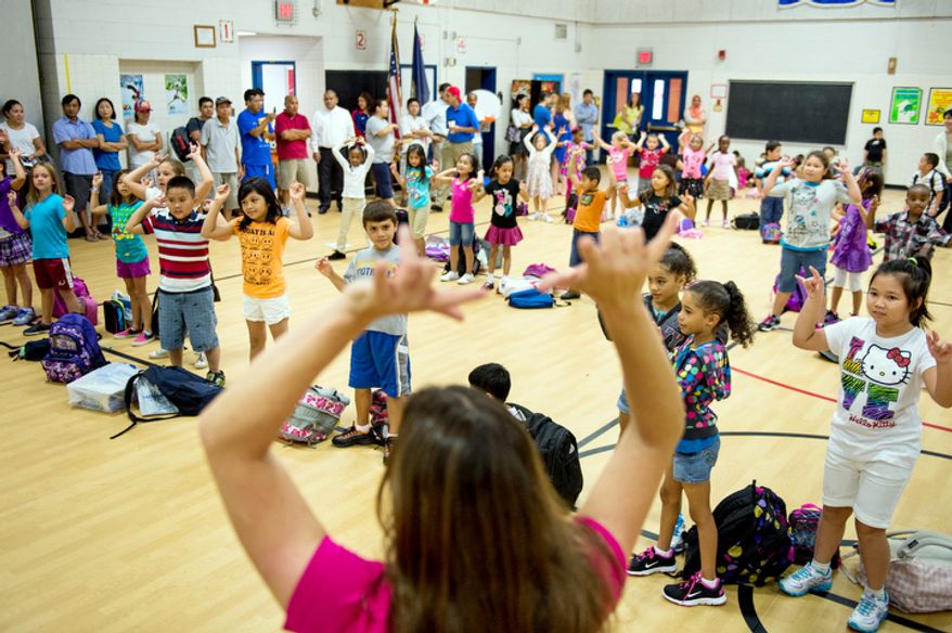 P.E. teacher Sue Metz gets students excited for their first day back to school at North Springfield Elementary School. (Andrew Harnik/The Washington Times)