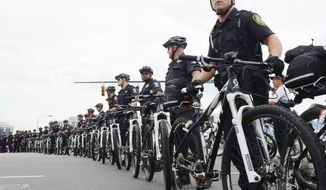 Police officers use their bicycles to create a perimeter to keep protesters inside a designated area along Stonewall Street in Charlotte, N.C. on Tuesday, Sept. 4, 2012. Protesters are allowed to march and demonstrate at the Democratic National Convention but are being kept well away from DNC venues. (Barbara L. Salisbury/The Washington Times)