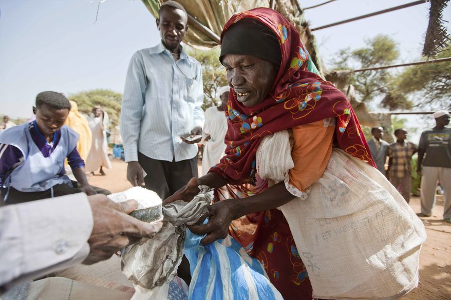 In this photo released by the United Nations-African Union Mission in Darfur (UNAMID), a woman receives sugar Aug. 27, 2012, from the World Food Program in a Kassab camp for Internally Displaced Persons. Civilians are beginning to return to their camps for the internally displaced following several weeks of unrest that began with the killing of a local official and his driver by a group of armed men. (Associated Press/UNAMID)