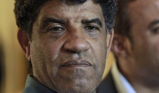 ** FILE ** Abdullah Senussi, head of Libyan intelligence, speaks to the press during a government-sponsored media tour as gunfire erupts all around the Rixos hotel in Tripoli, Libya, on Sunday, Aug. 21, 2011. (AP Photo/Dario Lopez-Mills)


