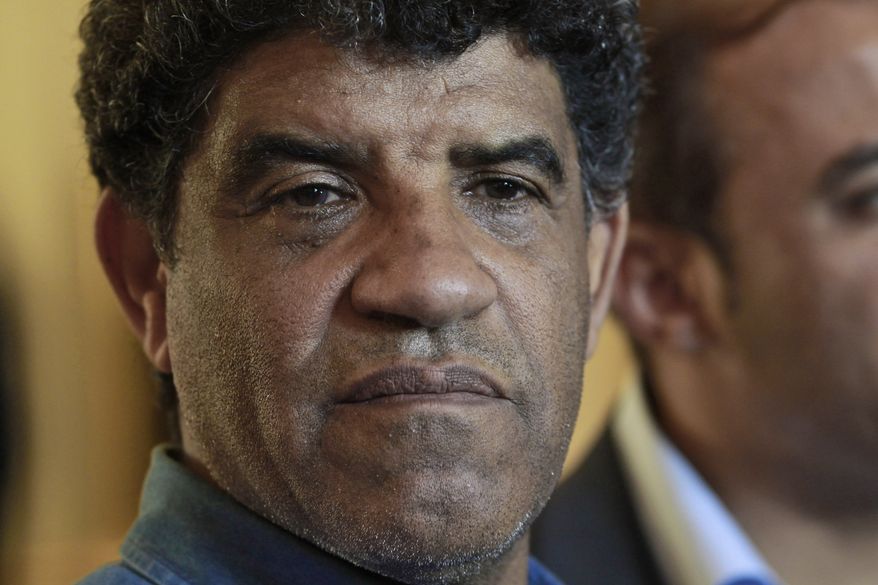 ** FILE ** Abdullah Senussi, head of Libyan intelligence, speaks to the press during a government-sponsored media tour as gunfire erupts all around the Rixos hotel in Tripoli, Libya, on Sunday, Aug. 21, 2011. (AP Photo/Dario Lopez-Mills)