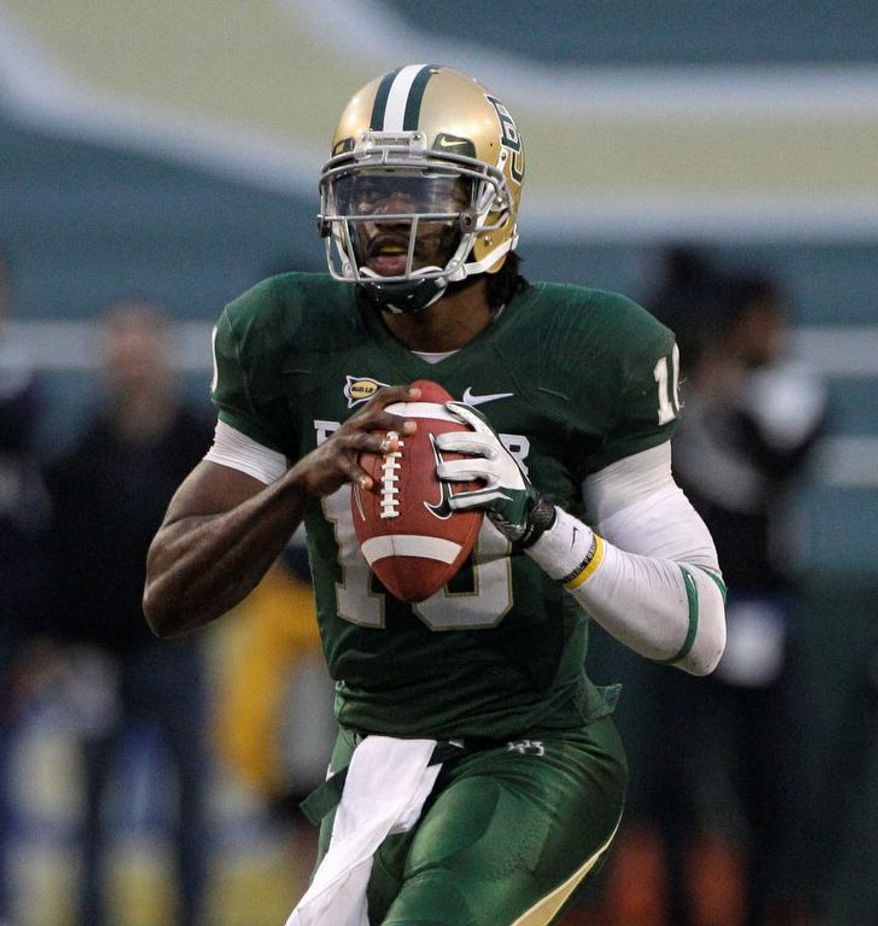 Baylor quarterback Robert Griffin III prepares to pass in the second half of an NCAA college football game against Texas Saturday, Dec. 3, 2011, in Waco, Texas. Griffin III ran for two touchdowns and passed for two more to lead No. 19 Baylor to a 48-24 win over Texas. (AP Photo/Tony Gutierrez)