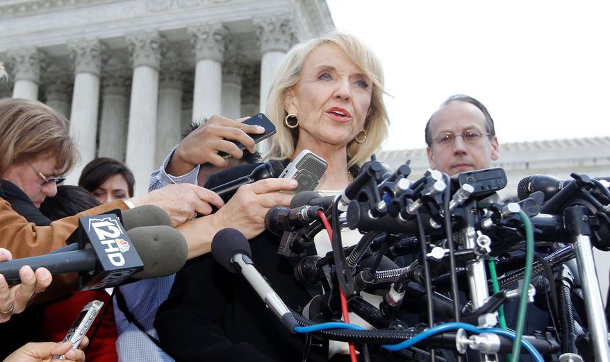 Gov. Jan Brewer two years ago signed landmark legislation requiring all Arizona police officers to check the immigration status of people they stop while enforcing other laws and suspect are in the country illegally. The requirement is expected to go into effect in the next several days. (Associated Press)