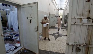 Libyans search for documents inside Abu Salim Prison, Libya&#39;s most notorious prison during Col. Moammar Gadhafi&#39;s regime and the scene of a 1996 massacre of prisoners, in Tripoli, Libya, on Saturday, Aug. 27, 2011. (AP Photo/Francois Mori)