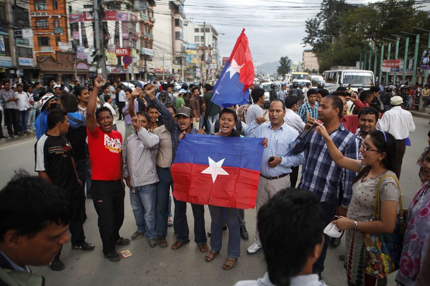 ** FILE ** A small group of Nepal Youth Front, the student organization of Communist Party of Nepal (Unified Marxist-Leninist), hold their flags and shout slogans during a protest against the hike of fuel prices in Katmandu, Nepal, Monday, Sept. 3, 2012. The state-owned Nepal Oil Corp. Sunday announced the rise in prices, which came into effect Monday. (AP Photo/Niranjan Shrestha)