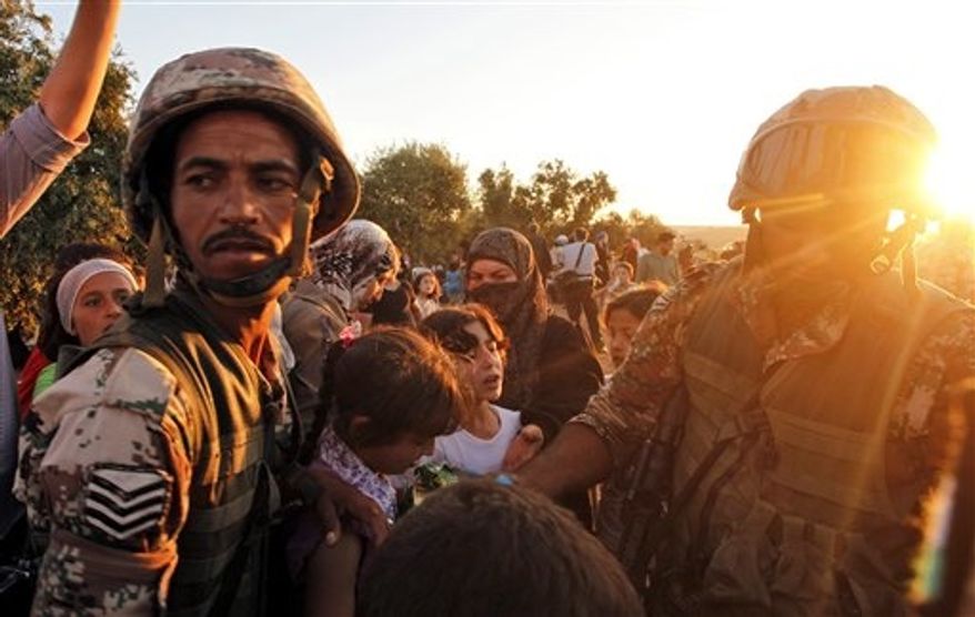 Newly-arrived Syrian refugee families receive food from the Jordanian military after they crossed the border from Tal Shehab city in Syria, through the Al Yarmouk River valley, into Thnebeh town, in Ramtha , Jordan, Wednesday, Sept. 5, 2012. More than 100,000 Syrians fled their country in August, the highest monthly total since the crisis began in March 2011, the U.N. refugee agency said Tuesday. (AP Photo/Mohammad Hannon)