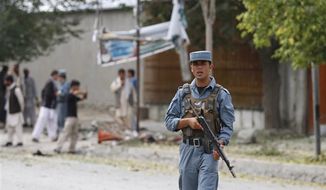 An Afghan policeman stands guard at the scene of a suicide bombing in Kabul Afghanistan, Saturday, 8, 2012. Afghan authorities say a suicide bomber has blown himself up near NATO headquarters in Kabul, killing at least 6 people (AP Photo/Ahmad Jamshid)