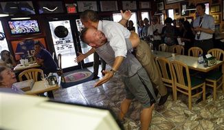 President Obama is lifted off the ground by Scott Van Duzer, owner of Big Apple Pizza and Pasta Italian Restaurant, on Sept. 9, 2012, during an unannounced stop at the restaurant in Ft. Pierce, Fla. (Associated Press)