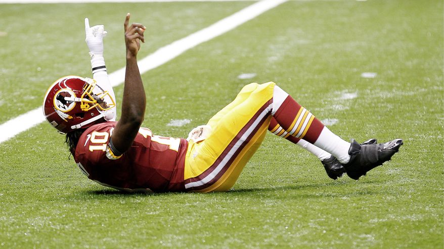 Redskins rookie quarterback Robert Griffin III celebrates after taking a shot from New Orleans safety Malcolm Jenkins on an 88-yard touchdown pass to wide receiver Pierre Garcon. The TD came on the first play from scrimmage after the Saints had taken a 7-3 lead. (Associated Press)