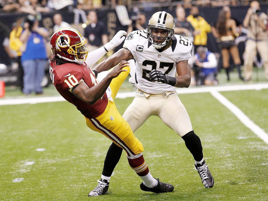 Washington Redskins quarterback Robert Griffin III (10) is hit by New Orleans Saints free safety Malcolm Jenkins (27) after after releasing the ball on touchdown pass in the first quarter of an NFL football game at the Mercedes-Benz Superdome in New Orleans, Sunday, Sept. 9, 2012. (AP Photo/Bill Haber)