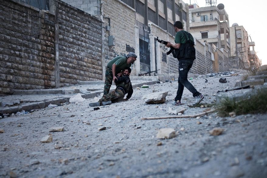 Free Syrian Army soldiers help a severely wounded colleague after he was shot by a Syrian army sniper in the Izaa district of Aleppo, Syria, on Saturday, Sept. 8, 2012. (AP Photo/Manu Brabo)