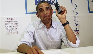 President Obama uses a cellphone to contact supporters during a surprise visit to meet volunteers at an Obama campaign office in Port St. Lucie, Fla. on Sept. 9, 2012. (Associated Press) **FILE**