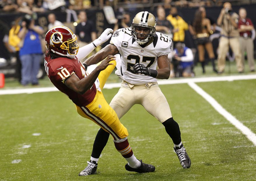 Washington Redskins quarterback Robert Griffin III (10) is hit by New Orleans Saints free safety Malcolm Jenkins (27) after after releasing the ball on touchdown pass in the first quarter of an NFL football game at the Mercedes-Benz Superdome in New Orleans, Sunday, Sept. 9, 2012. (AP Photo/Bill Haber)